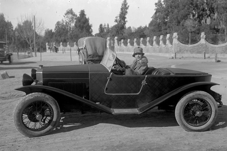 Mujer conduciendo vehículo antiguo